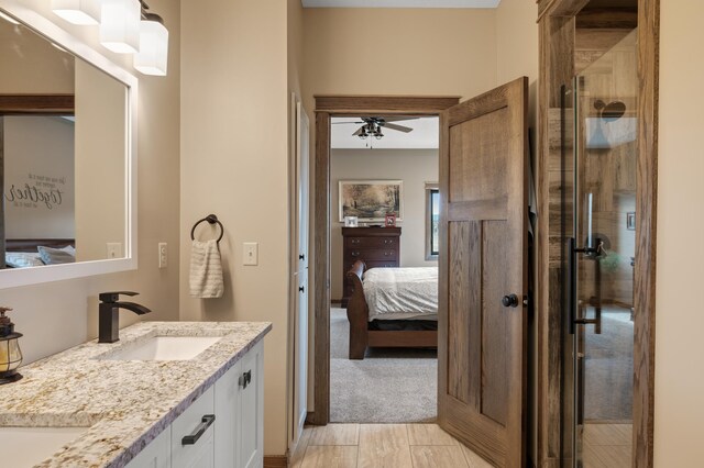 8530 Fir St, Greenfield, MN 55373 - full bathroom with connected bathroom, double vanity, a stall shower, a ceiling fan, and wood finished floors