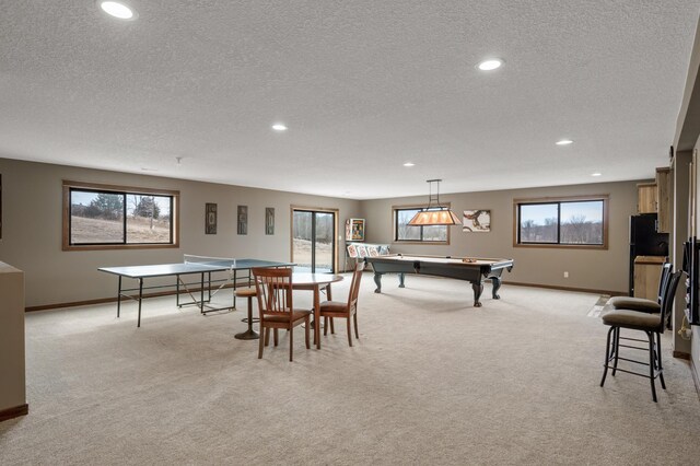 8530 Fir St, Greenfield, MN 55373 - recreation room with a textured ceiling, light colored carpet, recessed lighting, baseboards, and healthy amount of natural light