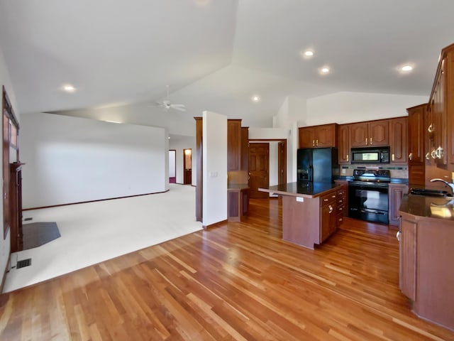 1101 Golfers Ct SE, Rochester, MN 55904 - kitchen with black appliances, a center island, vaulted ceiling, dark countertops, and ceiling fan