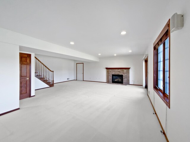 1101 Golfers Ct SE, Rochester, MN 55904 - unfurnished living room with light colored carpet, recessed lighting, a brick fireplace, stairs, and baseboards