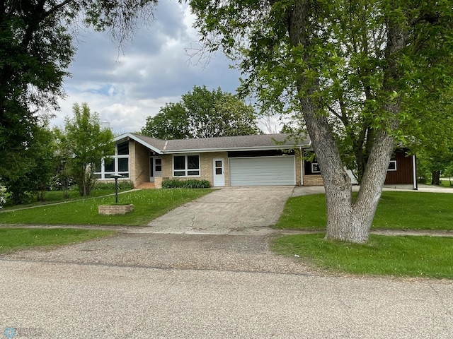 103 4th St S, Fairmount, ND 58030 - mid-century inspired home with brick siding, a front yard, a garage, and driveway