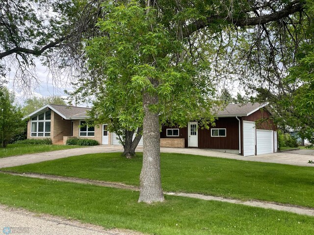 103 4th St S, Fairmount, ND 58030 - view of front of home with a front yard, driveway, a garage, and brick siding