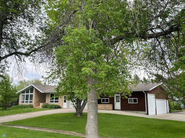 103 4th St S, Fairmount, ND 58030 - view of front of house with an attached garage, driveway, a front lawn, and brick siding