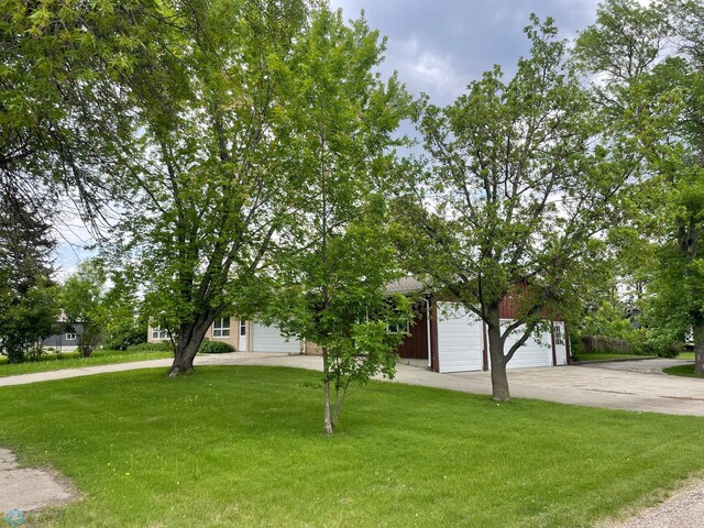 103 4th St S, Fairmount, ND 58030 - view of property hidden behind natural elements featuring a front lawn and a detached garage