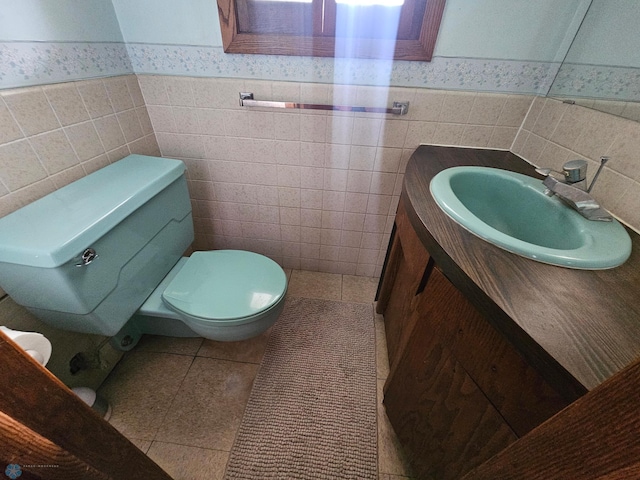 103 4th St S, Fairmount, ND 58030 - bathroom featuring tile walls, vanity, toilet, a wainscoted wall, and tile patterned floors