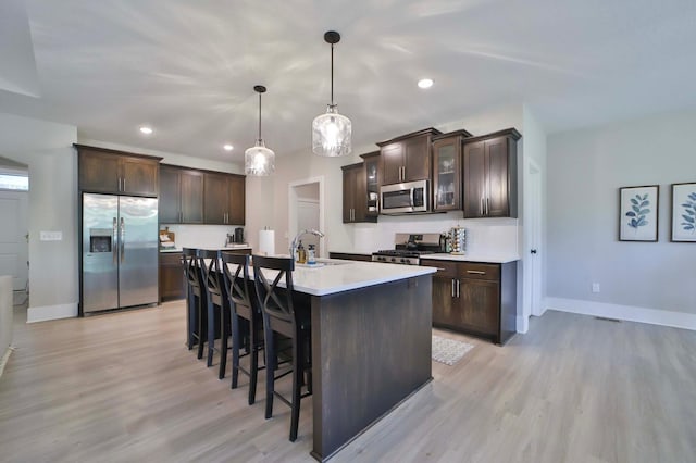 23904 Summer Haven Ln, Nisswa, MN 56468 - kitchen featuring appliances with stainless steel finishes, dark brown cabinetry, light wood-style floors, baseboards, and recessed lighting