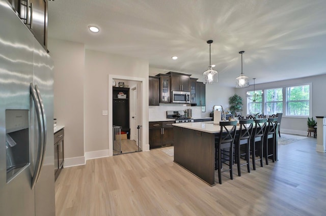 23904 Summer Haven Ln, Nisswa, MN 56468 - kitchen featuring stainless steel appliances, light wood finished floors, dark brown cabinetry, baseboards, and recessed lighting