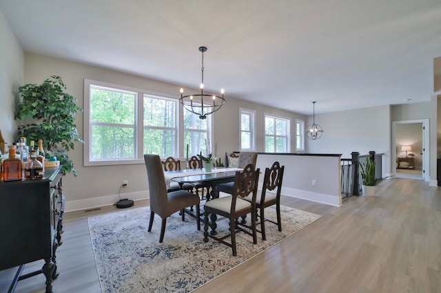 23904 Summer Haven Ln, Nisswa, MN 56468 - dining area featuring a chandelier, light wood-style floors, and baseboards
