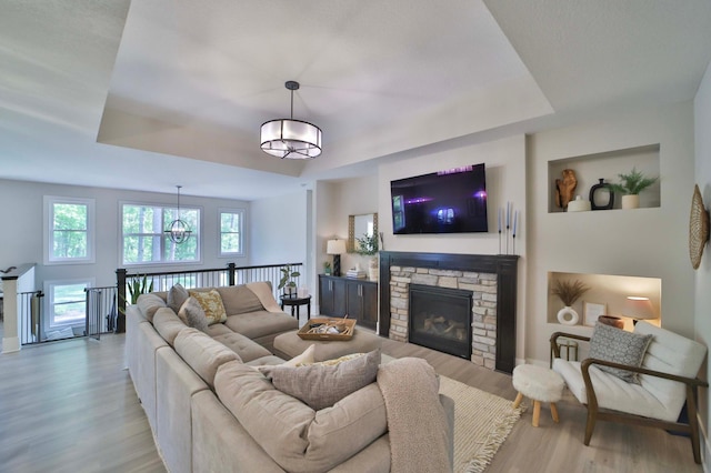 23904 Summer Haven Ln, Nisswa, MN 56468 - living area featuring a tray ceiling, light wood-style flooring, plenty of natural light, and a chandelier