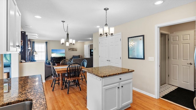 8548 139th St, Savage, MN 55378 - kitchen with a chandelier, light wood finished floors, white cabinetry, open floor plan, and decorative light fixtures