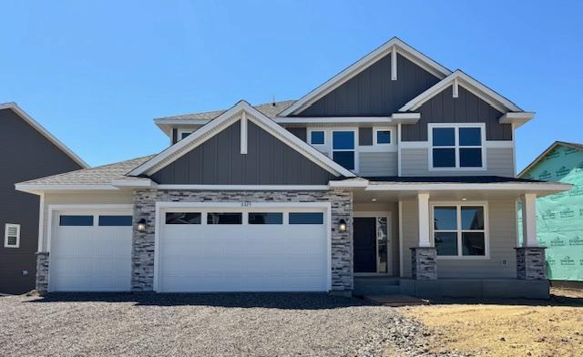 11325 Ithaca Ln N, Dayton, MN 55369 - craftsman-style home with a porch, board and batten siding, a garage, and gravel driveway