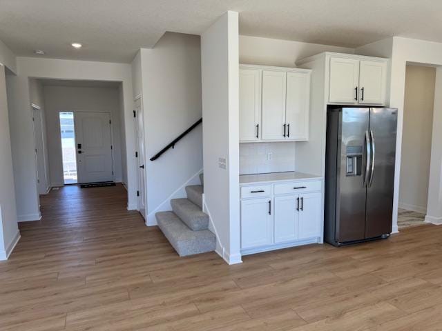 11325 Ithaca Ln N, Dayton, MN 55369 - kitchen with stainless steel fridge with ice dispenser, white cabinets, baseboards, light wood-style floors, and light countertops