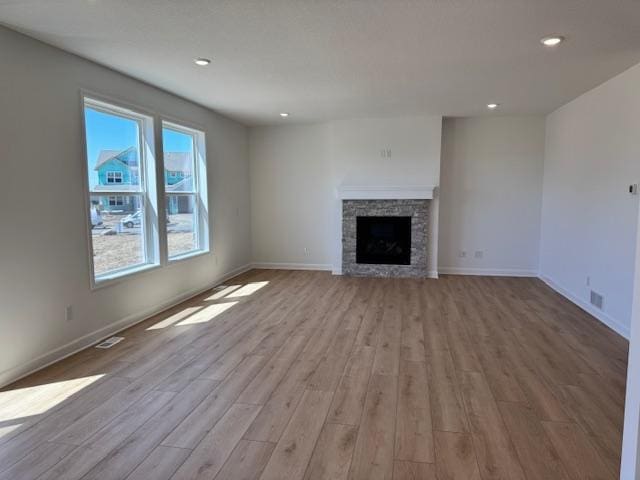 11325 Ithaca Ln N, Dayton, MN 55369 - unfurnished living room with wood finished floors, recessed lighting, baseboards, and a stone fireplace