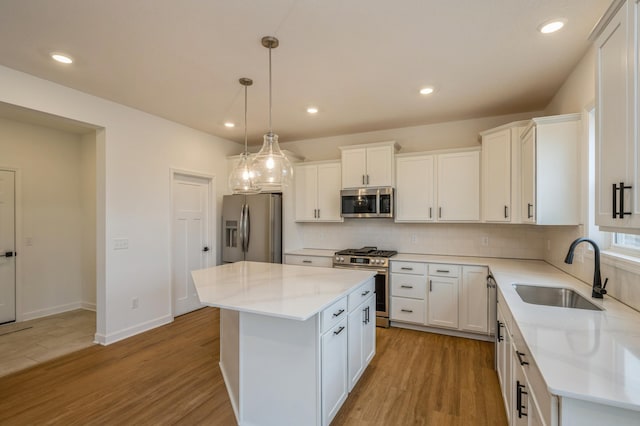260 Overlook Ct, Delano, MN 55328 - kitchen with appliances with stainless steel finishes, a sink, a kitchen island, decorative backsplash, and white cabinetry