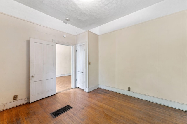 691 Burr St, Saint Paul, MN 55130 - unfurnished bedroom featuring hardwood / wood-style flooring, baseboards, and a textured ceiling
