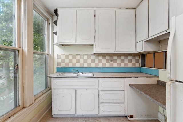 691 Burr St, Saint Paul, MN 55130 - kitchen with freestanding refrigerator, a sink, white cabinets, and tasteful backsplash