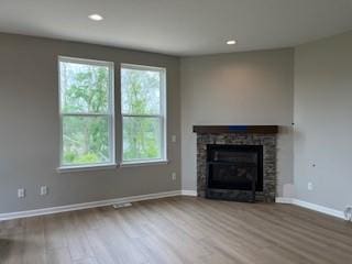 10051 Mulberry Ln, Corcoran, MN 55374 - unfurnished living room with wood finished floors, healthy amount of natural light, baseboards, recessed lighting, and a fireplace