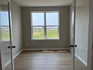 10051 Mulberry Ln, Corcoran, MN 55374 - empty room featuring wood finished floors, french doors, and baseboards