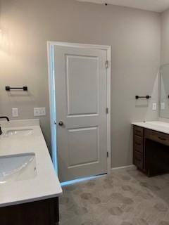 10051 Mulberry Ln, Corcoran, MN 55374 - bathroom featuring double vanity and baseboards