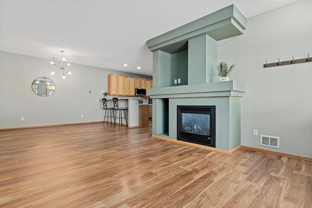 4707 Blaine Ave Unit 709, Inver Grove Heights, MN 55076 - unfurnished living room with light wood-style floors, a textured ceiling, a chandelier, recessed lighting, and baseboards