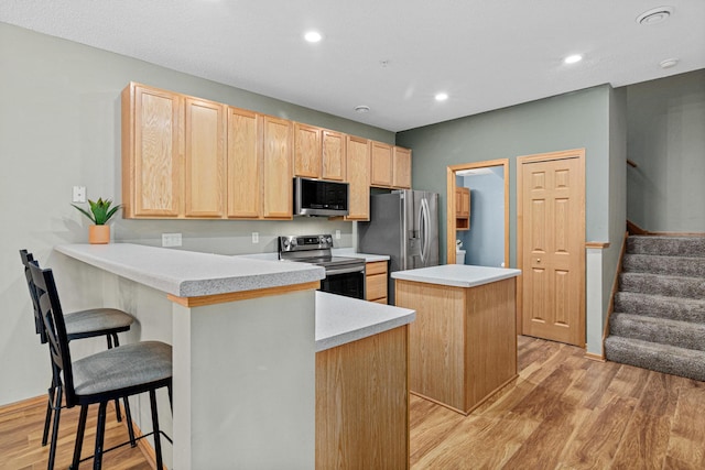 4707 Blaine Ave Unit 709, Inver Grove Heights, MN 55076 - kitchen featuring appliances with stainless steel finishes, light brown cabinetry, a center island, light wood-style flooring, and recessed lighting
