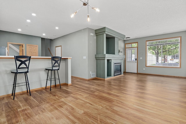 4707 Blaine Ave Unit 709, Inver Grove Heights, MN 55076 - living room with light wood finished floors, recessed lighting, baseboards, a glass covered fireplace, and a textured ceiling