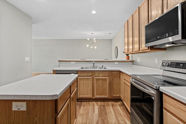 4707 Blaine Ave Unit 709, Inver Grove Heights, MN 55076 - kitchen with stainless steel appliances, light wood-type flooring, a sink, light countertops, and a chandelier