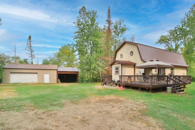 2155 County Road 55 NE, Remer, MN 56672 - rear view of house with a lawn, a gambrel roof, a detached garage, a wooden deck, and an outdoor structure