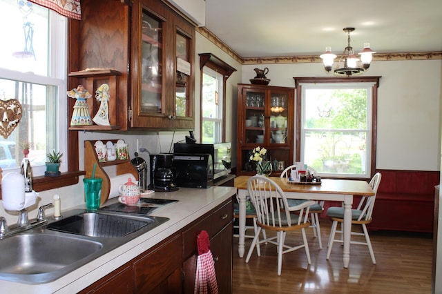 44500 Elmcrest Ave, Fish Lake Twp, MN 55032 - kitchen with a sink, a chandelier, wood finished floors, light countertops, and wainscoting