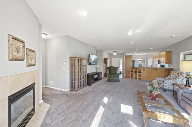 17260 Keystone Ave N, Hugo, MN 55038 - living area with a tile fireplace, light colored carpet, healthy amount of natural light, recessed lighting, and baseboards