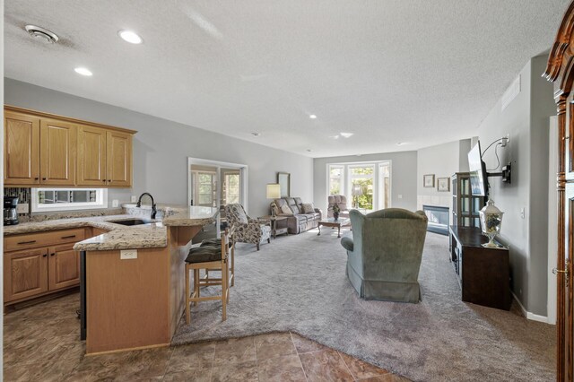 17260 Keystone Ave N, Hugo, MN 55038 - kitchen with a sink, a breakfast bar, open floor plan, a textured ceiling, and carpet