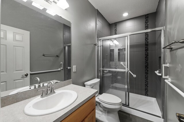 17260 Keystone Ave N, Hugo, MN 55038 - full bath with toilet, a shower stall, vanity, a textured ceiling, and recessed lighting