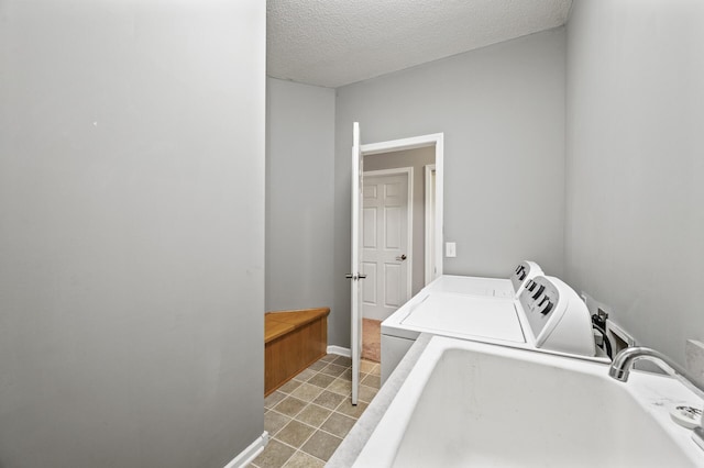 17260 Keystone Ave N, Hugo, MN 55038 - washroom featuring washing machine and clothes dryer, a sink, a textured ceiling, light tile patterned floors, and baseboards