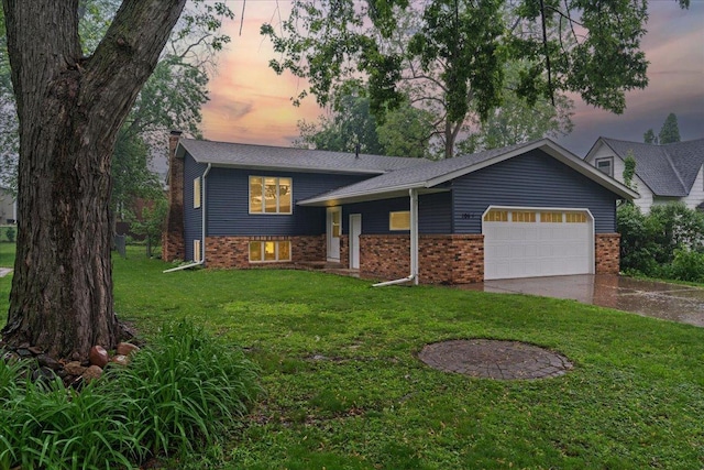 106 1/2 N St, Hudson, WI 54016 - split level home with an attached garage, concrete driveway, a front yard, and brick siding
