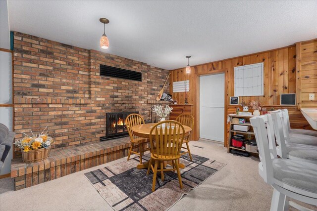 106 1/2 N St, Hudson, WI 54016 - carpeted dining area featuring a fireplace, wooden walls, and a textured ceiling