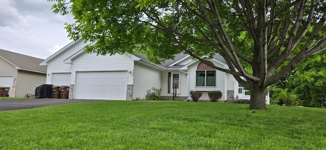 302 8th Ave S, Buffalo, MN 55313 - view of front of house featuring an attached garage, asphalt driveway, a front yard, and stone siding