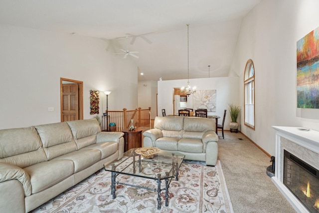 11202 Virginia Rd, Bloomington, MN 55438 - living area featuring a chandelier, high vaulted ceiling, light colored carpet, a ceiling fan, and a warm lit fireplace