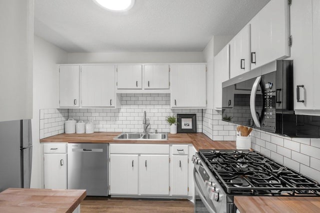 212 Eagle Lake Dr, Maple Grove, MN 55369 - kitchen with appliances with stainless steel finishes, a sink, butcher block counters, white cabinets, and a textured ceiling