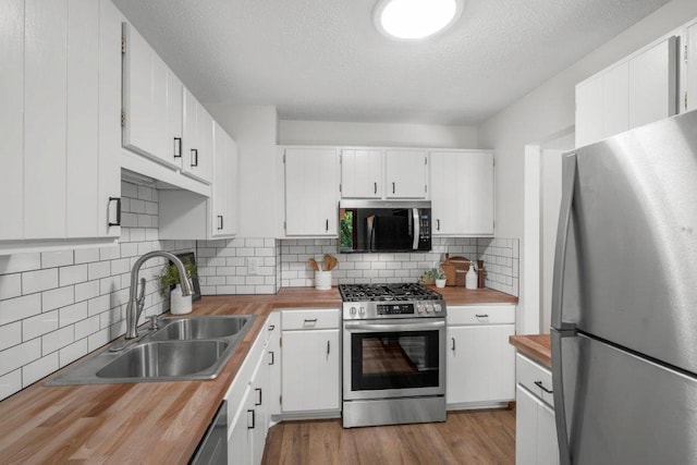 212 Eagle Lake Dr, Maple Grove, MN 55369 - kitchen featuring appliances with stainless steel finishes, wood counters, a sink, tasteful backsplash, and white cabinets