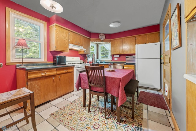 1413 11th Ave S, Fargo, ND 58103 - kitchen featuring white appliances, under cabinet range hood, light tile patterned floors, and brown cabinetry