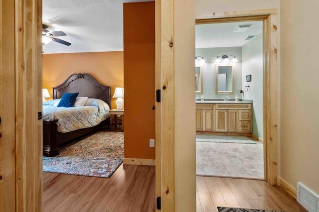31172 Apache Cir, Breezy Point, MN 56472 - bedroom featuring light wood-style floors, ensuite bathroom, baseboards, and a sink