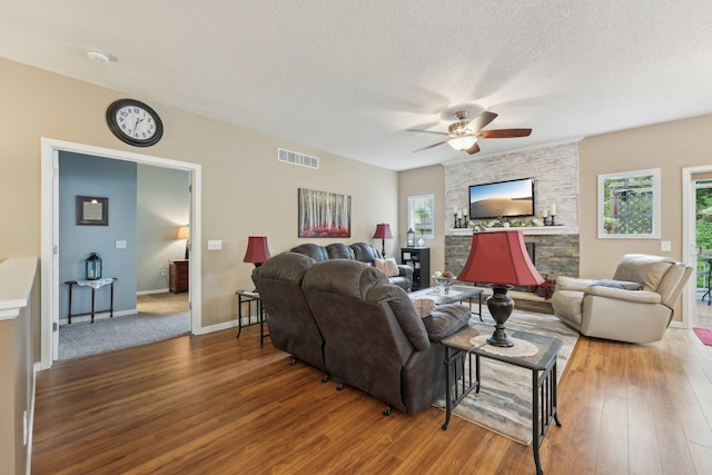 3157 Doneene Ln, Eagan, MN 55121 - living area with wood finished floors, ceiling fan, plenty of natural light, a stone fireplace, and a textured ceiling