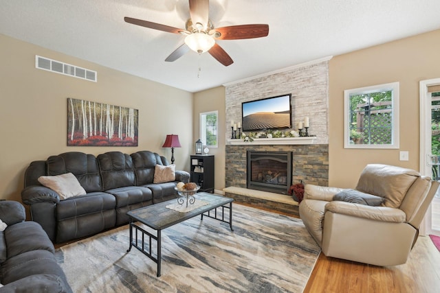 3157 Doneene Ln, Eagan, MN 55121 - living room with wood finished floors, a ceiling fan, and a stone fireplace