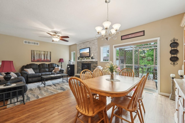 3157 Doneene Ln, Eagan, MN 55121 - dining space with light wood-style flooring, a fireplace, ceiling fan, and a chandelier