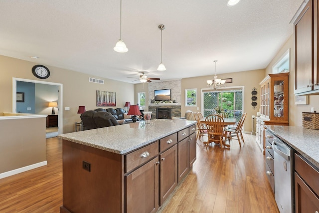 3157 Doneene Ln, Eagan, MN 55121 - kitchen featuring a fireplace, light wood-style floors, stainless steel dishwasher, ceiling fan, and hanging light fixtures