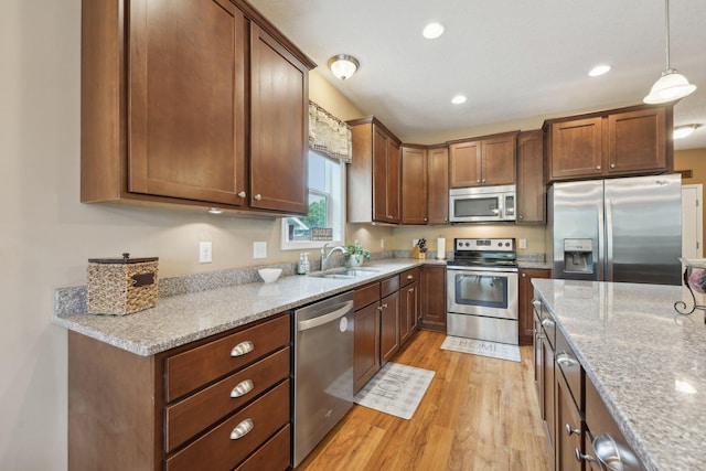 3157 Doneene Ln, Eagan, MN 55121 - kitchen with appliances with stainless steel finishes, a sink, light wood-style floors, light stone countertops, and hanging light fixtures