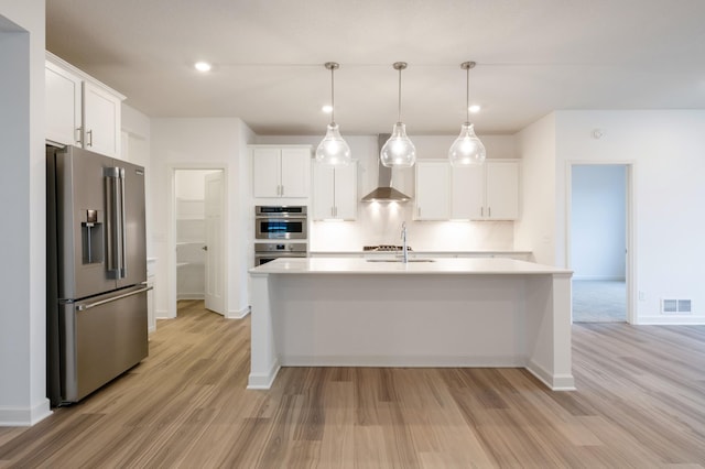 20106 68th Pl, Corcoran, MN 55340 - kitchen with stainless steel appliances, wall chimney range hood, light wood finished floors, light countertops, and white cabinetry