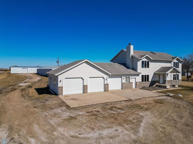 2717 88th Ave S, Fargo, ND 58104 - view of side of property with a garage, a chimney, and concrete driveway