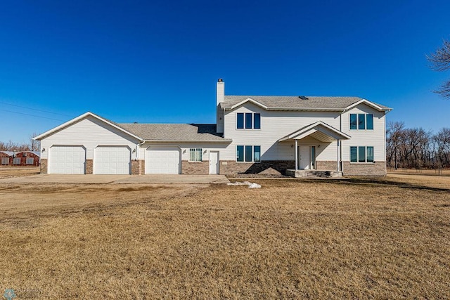 2717 88th Ave S, Fargo, ND 58104 - view of front facade with a garage, brick siding, a chimney, and a front lawn