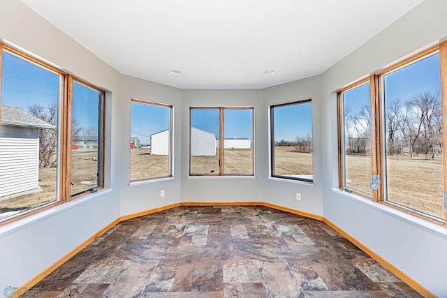 2717 88th Ave S, Fargo, ND 58104 - unfurnished sunroom with baseboards, stone finish floors, and recessed lighting